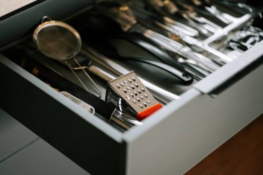 Mutfak çekmecesi yemek hazırlamak için çeşitli mutfak aletleri ve aletleriyle dolu.