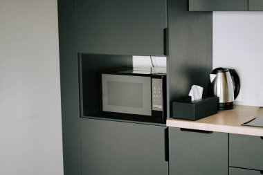 Modern mutfak köşesinde günlük kullanım için mikrodalga fırın ve su ısıtıcısı var.