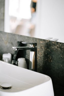 Çağdaş banyo lavabosu, parlak musluk ve minimalist tasarımla modern bir ortamda.