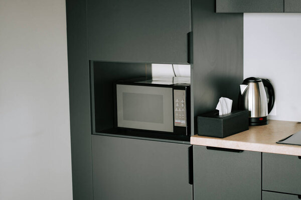 Современный кухонный уголок со встроенной микроволновой печью и крючком для повседневного удобства