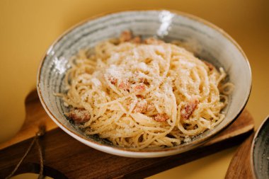 Tahta tepside kırsal bir kasede servis edilen leziz bolonez makarna.