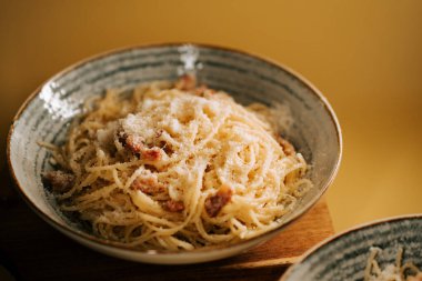 Tahta bir masada kırsal bir kasede servis edilen leziz bolonez makarna.