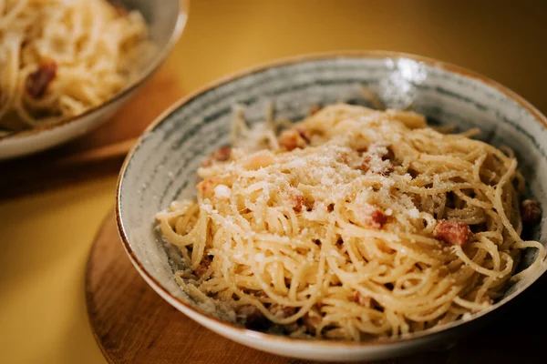 Sıcak bir yemek masasında şık kâselerde servis edilen leziz makarna bolonez.