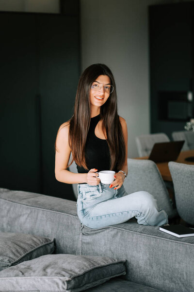 Young woman enjoying coffee in modern home with stylish decor and relaxed atmosphere
