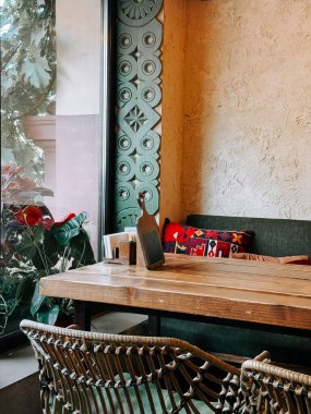 Güneşli bir öğleden sonra, kırsal dekorlu ve canlı yastıklı rahat kafe köşeleri.