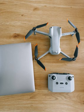 İnsansız hava aracı ve kumanda, hava fotoğrafçılığı hazırlığı için bir dizüstü bilgisayarın yanına yerleştirilmiş.