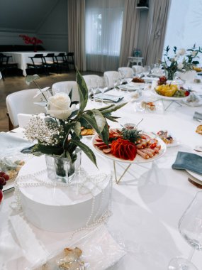 Özel bir gün için gurme yemekleri ve çiçek aranjmanları ile şık bir yemek düzeni.