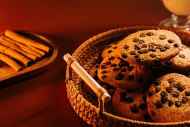 Tarçın çubuklarıyla dokuma sepetinde servis edilen taze pişmiş kurabiyeler.