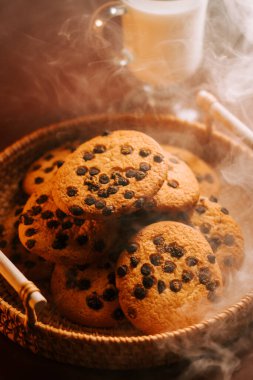 Sıcak bir mutfakta taze çikolata parçacıklı kurabiyeler pişiriyorum.