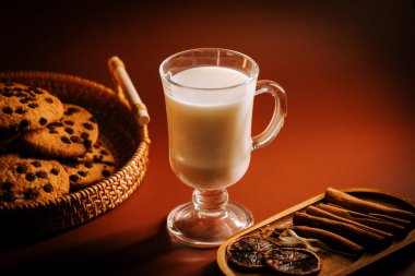 Lezzetli kurabiyeler ve sıcak süt. Baharatlı ve rahat bir sofrada.