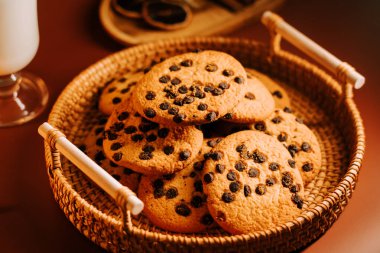 Tahta bir sepetin içinde taze pişmiş çikolatalı kurabiyeler.