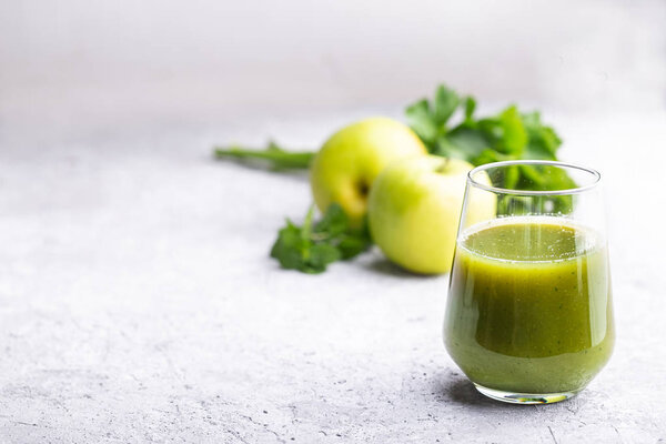 Green smoothie of apple, celery and mint on concrete background with copy space