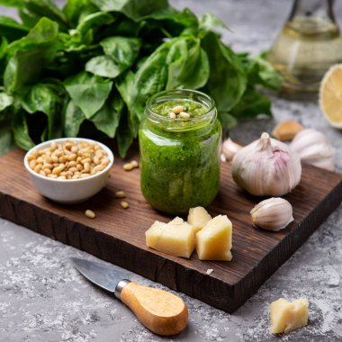 Pesto sos malzemeler (taze fesleğen, peynir, çam fıstığı, sarımsak ile bir şişe)