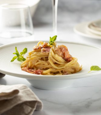 Koyu beyaz tabakta kekikli makarna.