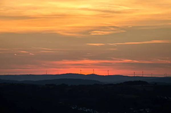 Günbatımı üzerinde Gladenbacher windpark. Rüzgar jeneratörleri günbatımı arka plan üzerinde siluetleri.