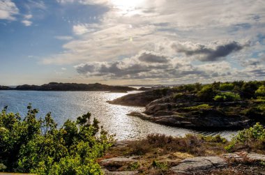 Flekkeroya 'da akşam güneşi. Kayalık Shor ile Seascape.