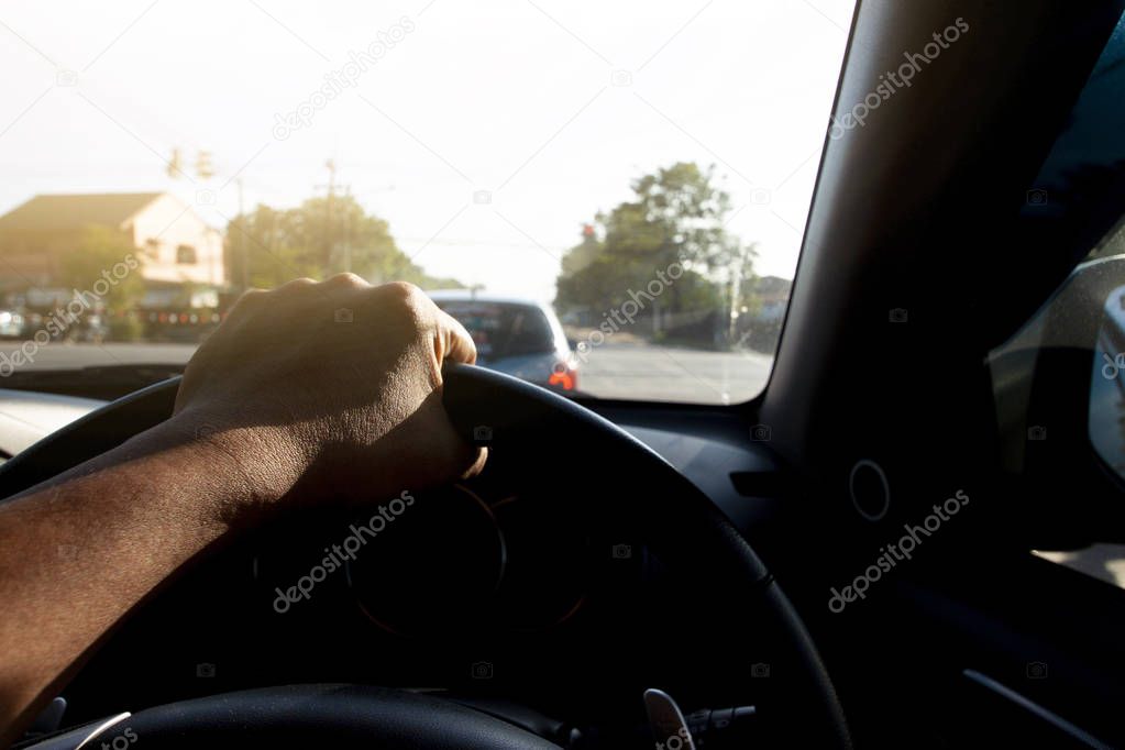 Man driving car stop in traffic light, Single hand on steering wheel, Go to business trip or travel.