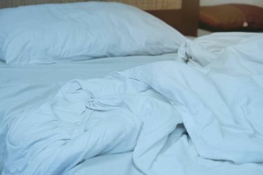 Buruşuk yatağın üzerindeki battaniye beyaz..