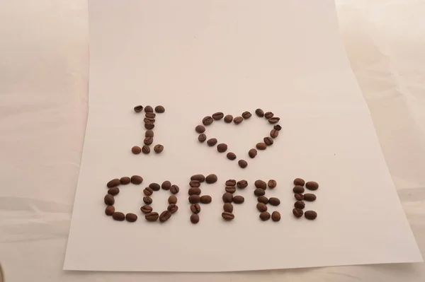 lettering I love coffee from coffee beans on white background