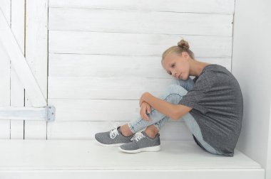 Kız gri bir ceket ve kot gri bir arka plan üzerinde Studio