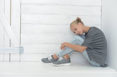 Kız gri bir ceket ve kot gri bir arka plan üzerinde Studio