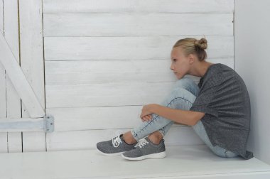 Kız gri bir ceket ve kot gri bir arka plan üzerinde Studio