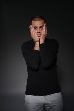 siyah ceketli adamı siyah bir zemin üzerine stüdyoda duygular gösterir