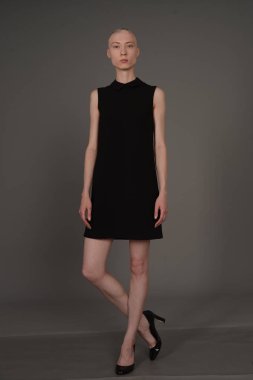 Kel kız stüdyoda Siyah elbisenin içinde poz