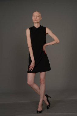 Kel kız stüdyoda Siyah elbisenin içinde poz