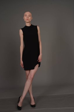 Kel kız stüdyoda Siyah elbisenin içinde poz