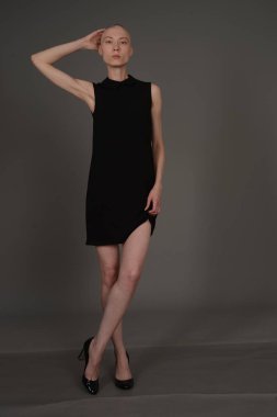 Kel kız stüdyoda Siyah elbisenin içinde poz