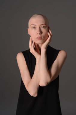 Kel kız stüdyoda Siyah elbisenin içinde poz