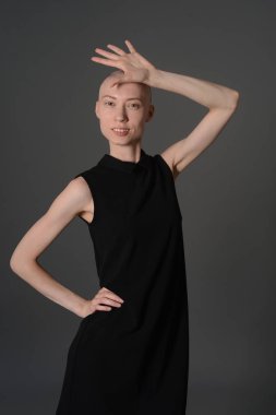 Kel kız stüdyoda Siyah elbisenin içinde poz