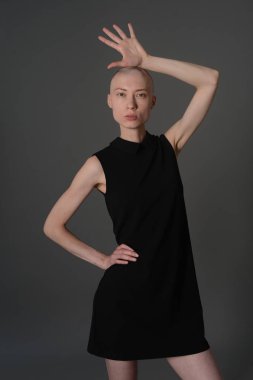 Kel kız stüdyoda Siyah elbisenin içinde poz