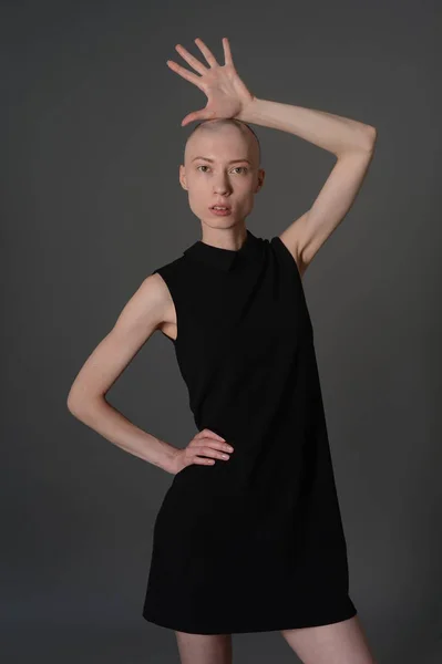Kel kız stüdyoda Siyah elbisenin içinde poz — Stok fotoğraf