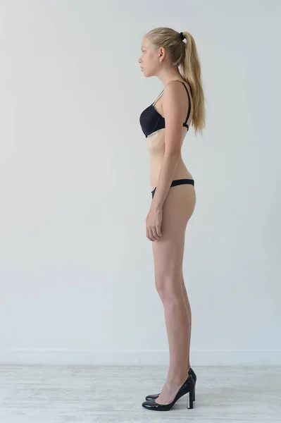 Modelo prueba chica en lencería negra con tatuaje posando en Studio sobre fondo gris —  Fotos de Stock