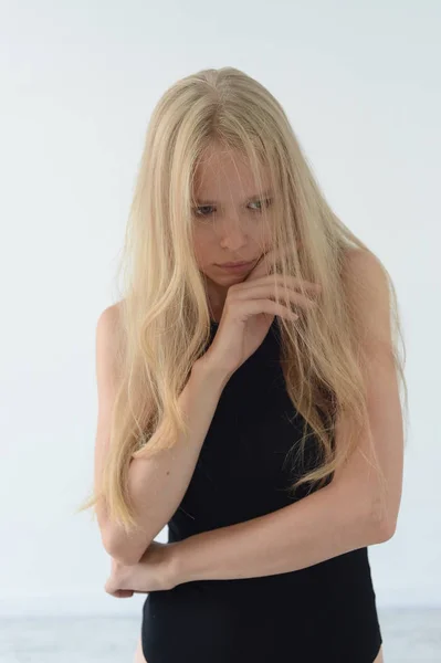 Fille en maillot de bain noir avec les cheveux blancs souriant et montrant des émotions dans le studio — Photo