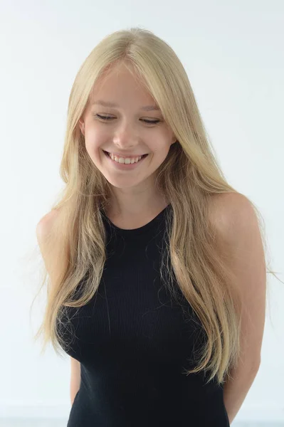Meisje in een zwarte zwembroek met witte haren glimlachend en het tonen van emoties in de Studio — Stockfoto