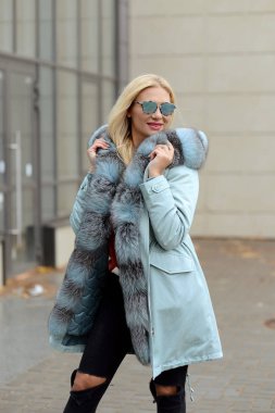 şehrin arka plan cam evlerin üzerine poz kürk ceket aşağı kız