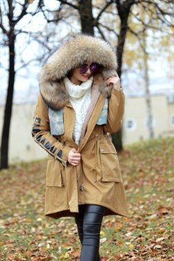 Kız ormanda yürüyüş kürk ve mavi gözlük aşağı ceket