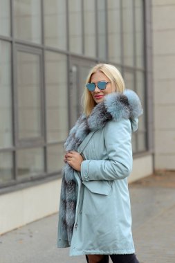 şehrin arka plan cam evlerin üzerine poz kürk ceket aşağı kız