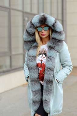 şehrin arka plan cam evlerin üzerine poz kürk ceket aşağı kız