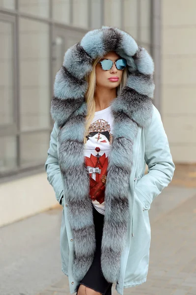 şehrin arka plan cam evlerin üzerine poz kürk ceket aşağı kız