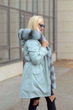 şehrin arka plan cam evlerin üzerine poz kürk ceket aşağı kız