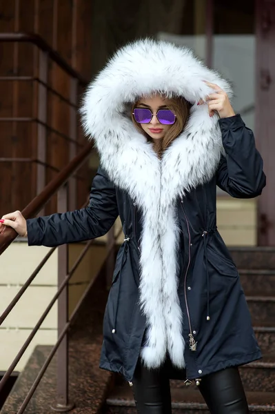 백색 모피 칼라와 안경 거리에 포즈 블랙 재킷에 여자 스톡 사진