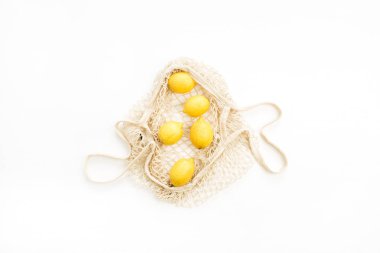 Beyaz arka plan üzerinde dize çantada taze çiğ limon. Düz yatıyordu, en iyi görünümü narenciye kavramı.