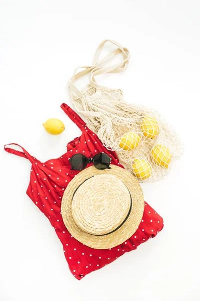 Yaz kadın moda kompozisyon. Kırmızı elbise, saman, dize çanta, güneş gözlüğü ve limon. Düz yatıyordu, en iyi görünümü.