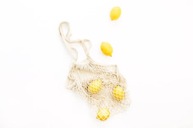 Beyaz arka plan üzerinde dize çantada taze çiğ limon. Düz yatıyordu, en iyi görünümü yaz konsepti.