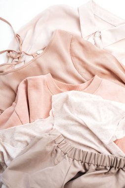 Kadın soluk pastel pembe giysiler. Kazak, Etek, gömlek beyaz arka plan üzerinde. Düz yatıyordu, en iyi görünüm çok az moda kavramı.