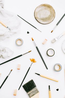 Sanatçı ev ofis resepsiyon çalışma boya fırçaları ve araçları beyaz arka plan üzerinde. Düz yatıyordu, en iyi görünümü yaratıcı en az kavramı.